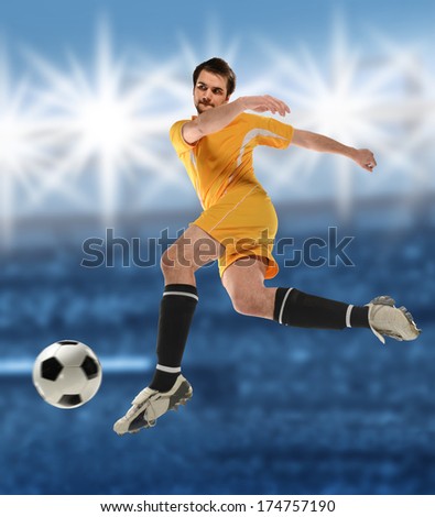 Young soccer player kicking ball inside stadium