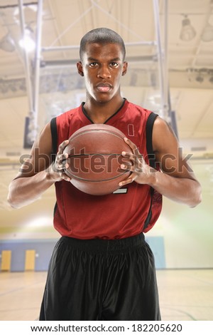 Portrait of African American basketball player with sweat on face holding ball