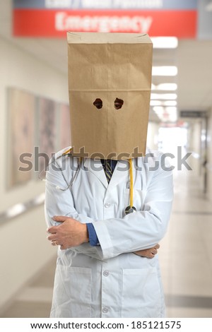 Doctor covering head with paper bag inside hospital