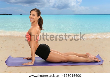 Young African American woman practicing yoga on tropical beach