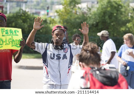FERGUSON, MO/USA -  AUGUST 15, 2014: Man holds hands up at the site of destroyed Quick Trip after Police Chief Thomas Jackson release of the name of the officer that shot Michael Brown.