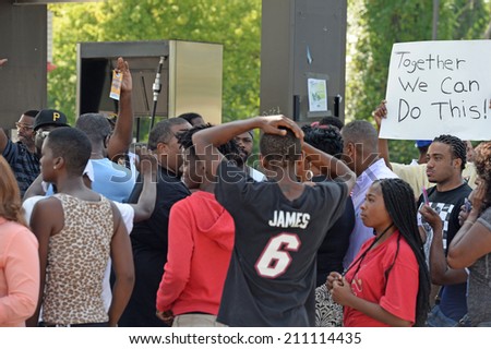 FERGUSON, MO/USA -  AUGUST 15, 2014: Crowd reacts at the Site of Quick Trip after Police Chief Thomas Jackson release of the name of the officer that shot Michael Brown.