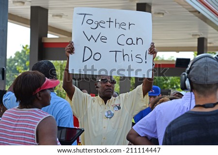 FERGUSON, MO/USA -  AUGUST 15, 2014: Man holds sign at the site of Quick Trip after Police Chief Thomas Jackson release of the name of the officer that shot Michael Brown.