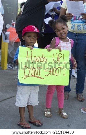FERGUSON, MO/USA -AUGUST 15, 2014: Children hold sign at the Site of Quick Trip after Police Chief Thomas Jackson release of the name of the officer that shot Michael Brown.