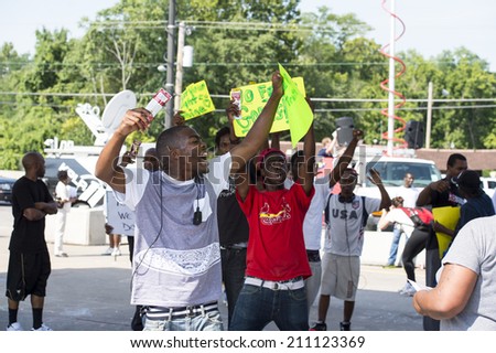 FERGUSON, MO/USA  AUGUST 15, 2014: Demonstrator at the site of destroyed Quick Trip react after Police Chief Thomas Jackson release of the name of the officer that shot Michael Brown.