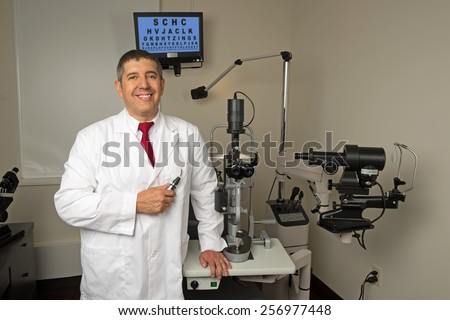 Hispanic eye doctor in examination room surrounded by testing machines