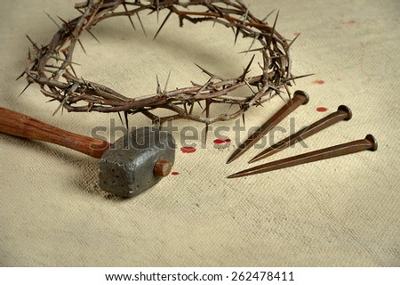 Christian symbols of the crucifixion with crown of thorns, nails and mallet on distressed cloth