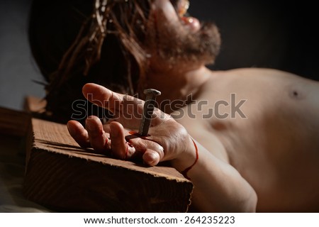 Jesus  on the cross with nail and hand in foreground