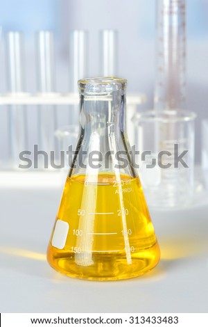 Beaker with yellow colorant on laboratory table