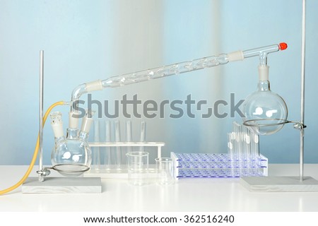 Laboratory glassware with distillation set on white table