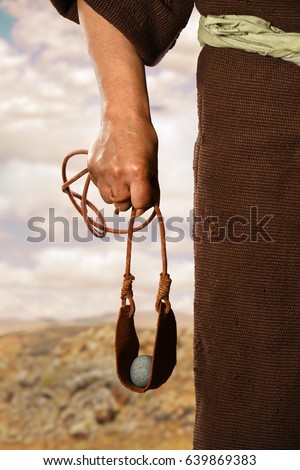 Hand of biblical David holding sling shot with stone