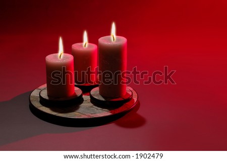 Three Candles over red background