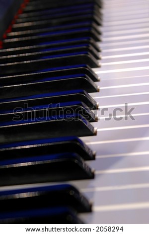 Piano keyboard in a vertical view with blue light reflections