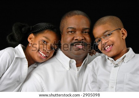 Father with daughter and son in a close-up portrait over a black background