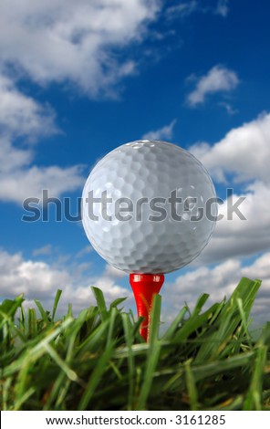 Golf ball and tee over a blue sky and clouds.