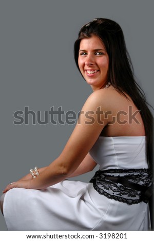 Smiling teen with her prom dress over a gray background