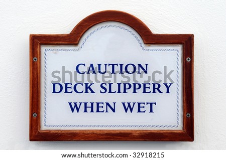 Caution Deck Slippery When Wet sign on a white wall