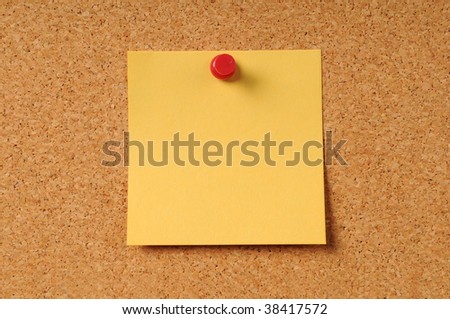 Adhesive note pinned to cork board by red pin