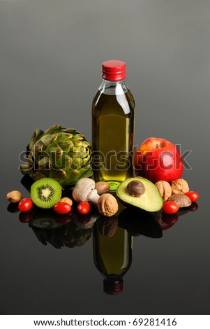 Fresh fruits and vegetables and olive oil on reflective table