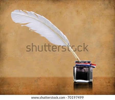 Vintage writing quill and inkwell over grunge background