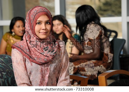 Islamic Young woman with diverse group of female students dressed in traditional clothing inside school setting