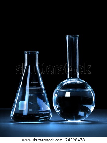 Laboratory glassware with blue light over dark background - With Clipping Path
