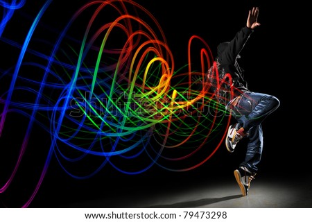 African American hip hip dancer with waves of light painting over dark  background