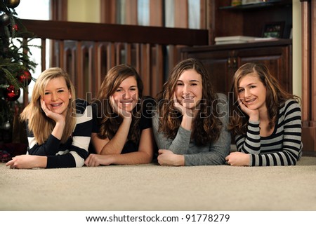 Group of young women laying on floor smiling indoors