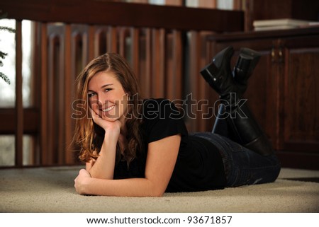 Portrait of beautiful young woman laying on floor smiling
