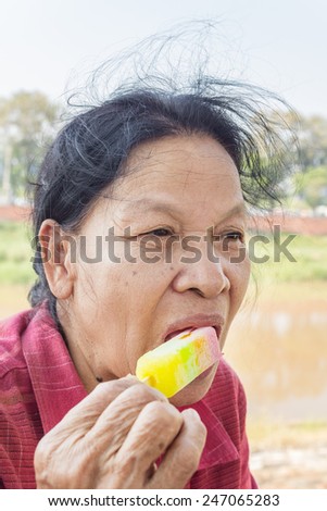 Closeup of Asian Thai old woman eating ice cream