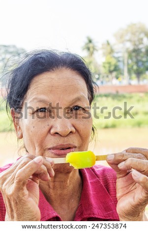 Closeup of Asian Thai old woman eating ice cream