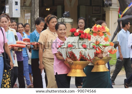 NAKHON SI THAMMARAT, THAILAND - DEC 02 : Unidentified Thai women hold flower offering in parade of Celebration of candidate Buddhist novice on December 02, 2011 at Nakhon Si Thammarat, Thailand
