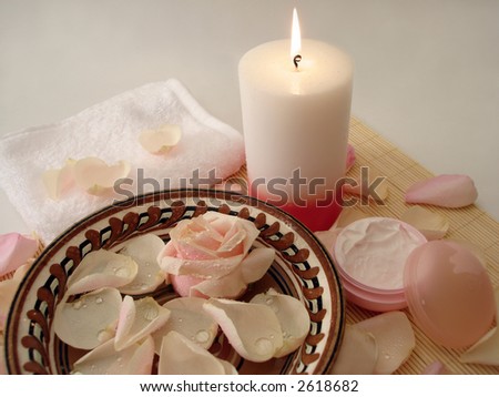 Spa essentials (pink candle, white towel and rose in water)