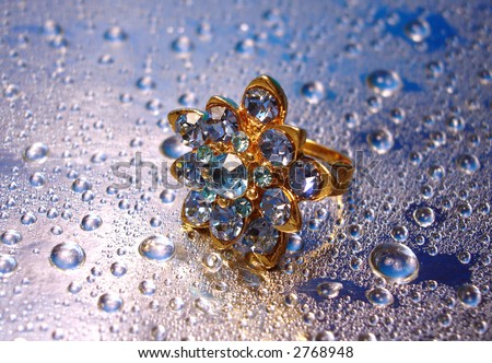 beautiful blue ring on silver background with drop of water