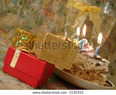 celebratory table (piece of birthday cake and blue candle, two glasses with champagne, gift boxes)
