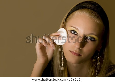 young attractive blond girl applying face pack