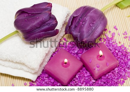 Spa essentials (candles, towel, salt and violet flowers)
