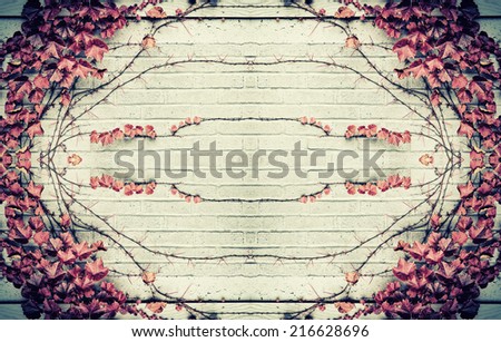 A design of stylized from real grape vines and autumn red leaves in the center and border of a gray brick wall.  Room for copy space.  Filtered for a vintage retro look.