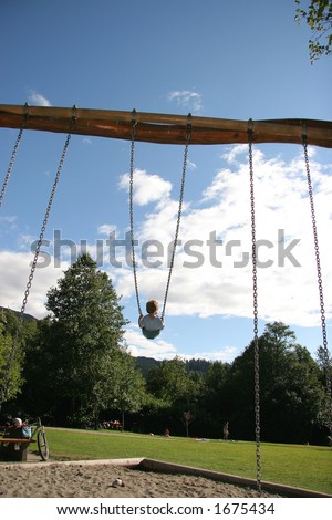 Little boy on swing wants to go higher!