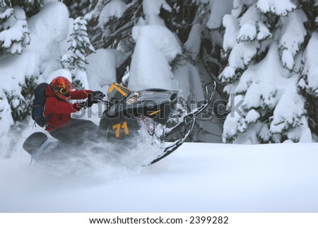 A skilled snow machine rider gets weightless while flying through deep powder snow.