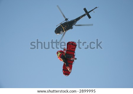 stock-photo-a-rescue-worker-flies-under-a-helicopter-with-a-patient-in-a-rescue-stretcher-2899995.jpg