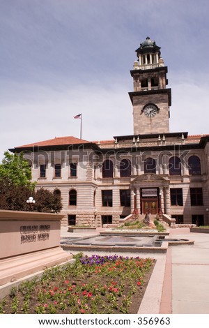 Wide view (vertical orientation) of the front of the old El Paso County, Colorado, courthouse, now the Pioneer Museum, with flower beds in the foreground.