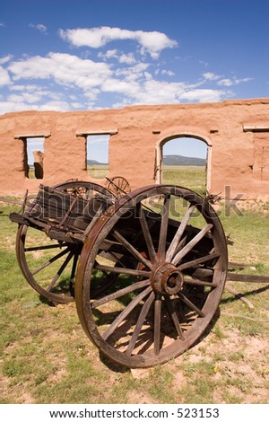 Adobe walls and window gaps form part of the stables and mechanics' work area, with antique wagon, at old Fort Union National Monument north of Santa Fe, New Mexico