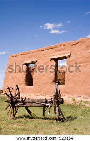 Adobe walls and window gaps form part of the stables and mechanics\' work area, with antique wagon, at old Fort Union National Monument north of Santa Fe, New Mexico