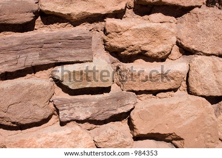 Closeup of the side of a stone and adobe mud wall at an old Spanish mission in New Mexico for background uses.
