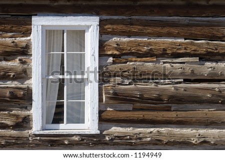 A whitewashed window (left side) in an old log wall on a homestead in Colorado.