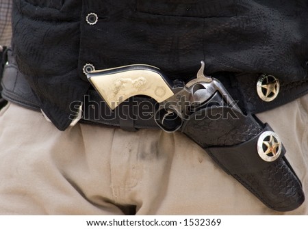 An old fashioned gunbelt below the leather vest of a gunfighter, complete with silver conchos and ivory-handled pistol
