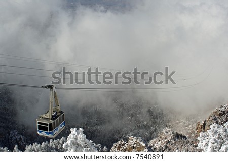 The Sandia Mountain tram rises out of the clouds of an early winter storm - horizontal