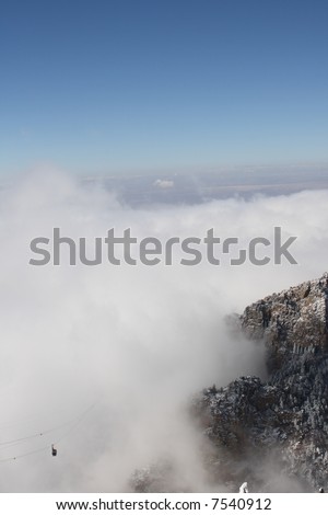 The Sandia Mountain tram rises out of the clouds of an early winter storm - vertical orientation