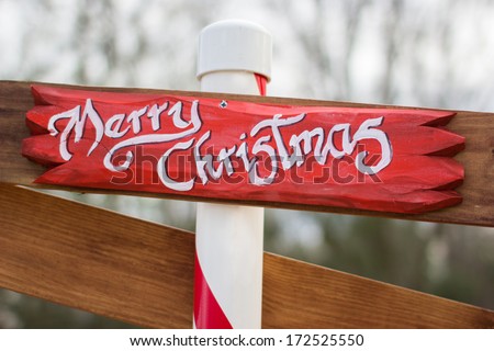 Handmade Wooden Merry Christmas sign mounted on pole.  Shallow depth of field.